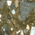 Plate 126.2: Photomicrograph of trituration grits on VER WH (XPL) (width of field 1.74 mm). Click to see a larger version